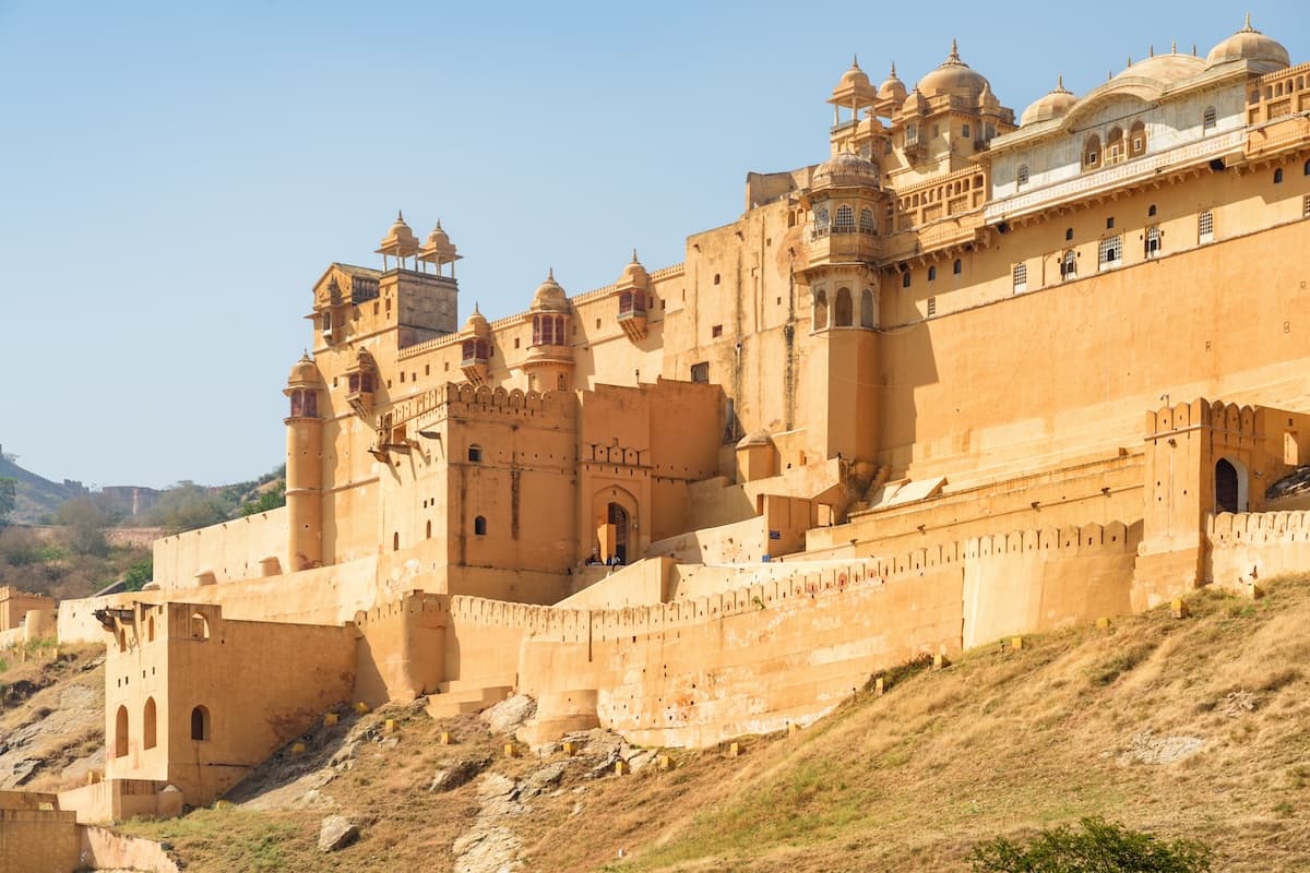 Amer Fort above the Maota Lake near Jaipur in Rajasthan — sandstone walls, terraced courtyards and the surrounding Aravalli ridges.